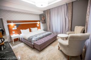 1 dormitorio con 1 cama y 1 silla en Charleson Luxury Hotel, en Port Harcourt