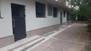 a building with a black door and a sidewalk at Ая in Vratsa