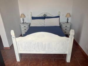 1 cama blanca en un dormitorio con 2 mesitas de noche en Viva España, en Comares