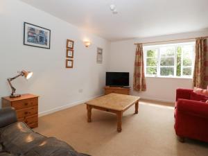 a living room with a couch and a coffee table at Wheelbarrow Cottage in Stoke Prior
