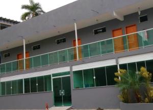 a building with green and orange windows and doors at Hospedagem de Jesus in Aparecida