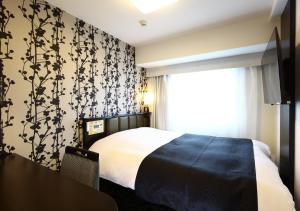 a bedroom with a bed with a black and white patterned wall at APA Hotel Ueno Ekimae in Tokyo