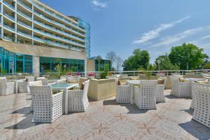 a patio with tables and chairs in front of a building at Marina Grand Beach Hotel - All Inclusive Plus in Golden Sands