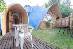 a house with a table and chairs on a deck at Casa circular in San Carlos de Bariloche