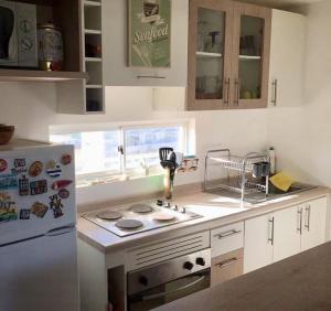 uma cozinha com um fogão e um frigorífico branco em Departamento vista al mar em El Tabo
