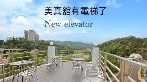 a balcony with tables and chairs on a new elevator at Mei Jen house B&B 日月潭民宿 in Yuchi