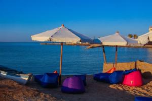 a beach area with umbrellas and chairs at Boulevard Apartment Hotel in Hurghada