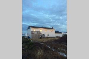 een wit huis bovenop een heuvel bij Ocean Front House in Cook's Harbour Newfoundland in Raleigh +17 foto's