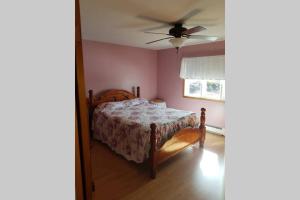 een slaapkamer met een bed en een plafondventilator bij Ocean Front House in Cook's Harbour Newfoundland in Raleigh