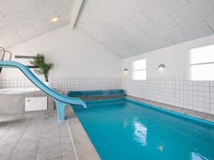 einen Pool mit blauer Rutsche in einem Zimmer in der Unterkunft 16 person holiday home in L kken in Nørre Lyngby