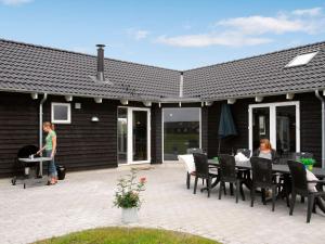 zwei Frauen sitzen an einem Tisch auf einer Terrasse in der Unterkunft 16 person holiday home in L kken in Nørre Lyngby