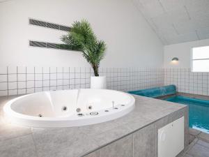 eine Badewanne mit einer Palme im Bad in der Unterkunft 16 person holiday home in L kken in Nørre Lyngby