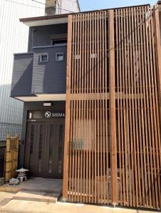 a building with a wooden fence in front of it at KYOTO SHIMA in Kyoto