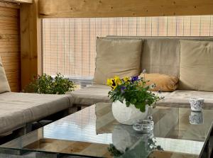 a living room with a couch and a glass table with flowers at Vacation House Terraces in Sigulda