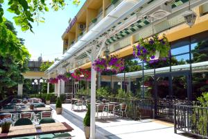 an outdoor patio with tables and chairs and flowers at Hotel Tiara in Ploieşti