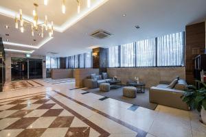 a lobby with couches and tables in a building at Browndot Hotel Incheon Songdo in Incheon