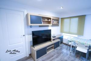 a living room with a flat screen tv and a table at Piso las Artes in Avilés