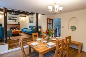 a dining room and living room with a table and chairs at Eleri Cottage in Great Malvern