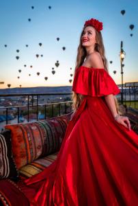 a woman in a red dress standing next to a couch at Lord of Cappadocia Hotel in Goreme