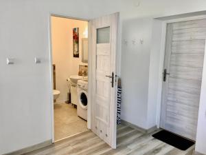 a bathroom with a washer and dryer and a door at VILLA MARYNARZA in Ustka