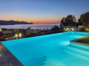 a swimming pool with a view of the ocean at dusk at Villa Piscina sul Mare in Alcamo Marina