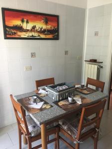 uma mesa de jantar com cadeiras e um quadro na parede em Big family bed & breakfast em Suello