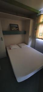 ein großes weißes Bett in einem Zimmer mit Fenster in der Unterkunft PRATICCIONI in Linguizzetta