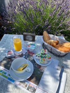 a table with food and a basket of bread and orange juice at Le Narval in Saint-Jean-de-Monts