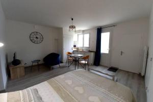 Un dormitorio con una cama y una mesa y sillas. en Gîte "Chez Albert et Cie"- 8 mn du Puy du Fou, en Les Herbiers