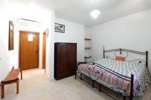 Schlafzimmer mit einem Bett und einer Holztür in der Unterkunft Agriturismo con Trullo in Alberobello