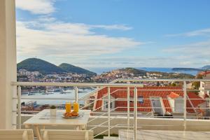 a balcony with a table and a view of a city at Apartments Muminovic in Dubrovnik