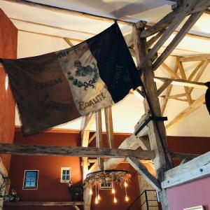 eine Flagge, die von der Decke eines Gebäudes hängt in der Unterkunft Chambre familiale Élevage Girbal in La Chapelotte