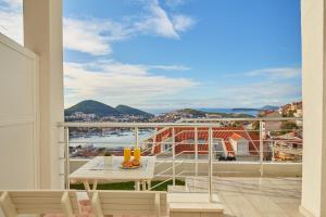 a balcony with a table and a view of the ocean at Apartments Muminovic in Dubrovnik