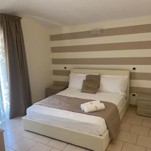 ein Schlafzimmer mit einem Bett mit gestreifter Wand in der Unterkunft Affittacamere" SANTA LUCIA" in Roccarainola