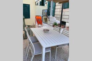 uma mesa branca e cadeiras num pátio em Piazza Anco Marzio fronte mare casa con giardino em Lido di Ostia