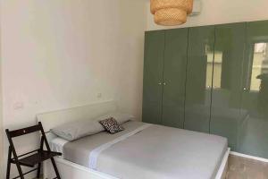 um pequeno quarto com uma cama e uma cadeira em Piazza Anco Marzio fronte mare casa con giardino em Lido di Ostia