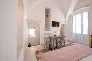 een slaapkamer met een tafel en stoelen in een kamer bij La Contessina in Ostuni
