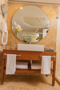 W łazience znajduje się umywalka i lustro. w obiekcie Enjoy Dead Sea Hotel -Formerly Daniel w mieście En Bokek