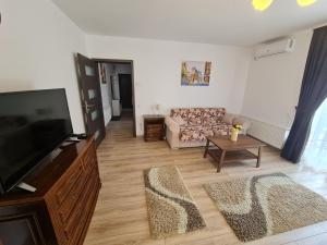 a living room with a flat screen tv and a couch at Select City Center in Târgu-Mureş