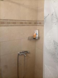 een douche met een douchekop in de badkamer bij Μπαλκόνι στο Αιγαίο in Kalamaki