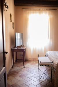 a bedroom with a desk and a bed and a window at Locanda Le Logge in Urbisaglia