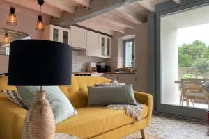 uma sala de estar com um sofá amarelo e uma cozinha em Adosado La Concha em Llanes