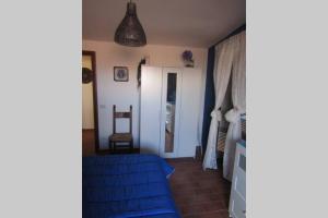 1 dormitorio con 1 cama azul y 1 silla en Casa Angelina, en Gavignano