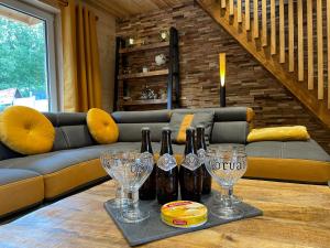 una mesa con botellas de vino y copas de vino. en La Petite Maison au bord de l'eau en Hastière-par-delà