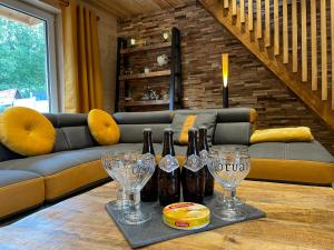 a table with wine bottles and wine glasses on it at La Petite Maison au bord de l'eau in Hastière-par-delà