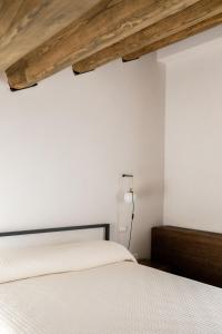 a bedroom with a white bed and a wooden ceiling at Locanda Le Logge in Urbisaglia