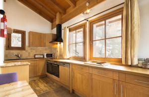 a kitchen with wooden cabinets and a window at Chalet Chardons Belvedere in Tignes