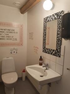 a bathroom with a toilet and a sink and a mirror at Klåveröd logi & café in Kågeröd