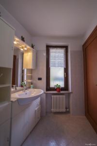 baño blanco con lavabo y ventana en Dimora Gilles, Aosta, Alloggio ad uso turistico VDA ISSOGNE n0003, en Issogne
