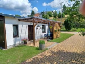 uma casa com uma pérgola ao lado em Ferienwohnung em Reinhardtsdorf